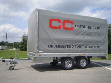 grosser Pritschen Anhaenger mit Plane und CC Lindenmeyer Logo