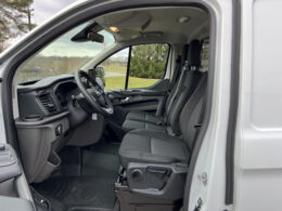 Blick durch geoeffnete Fahrertuer in den Ford Custom Transporter